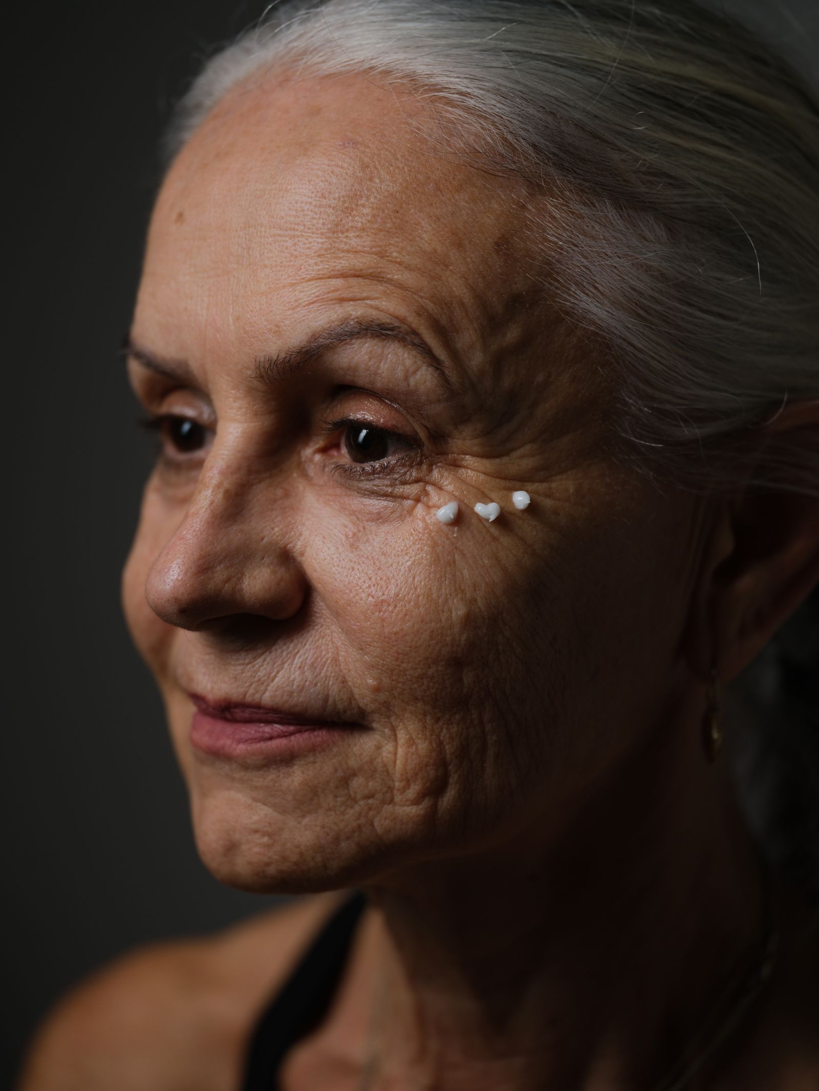 Older woman applying facial moisturiser